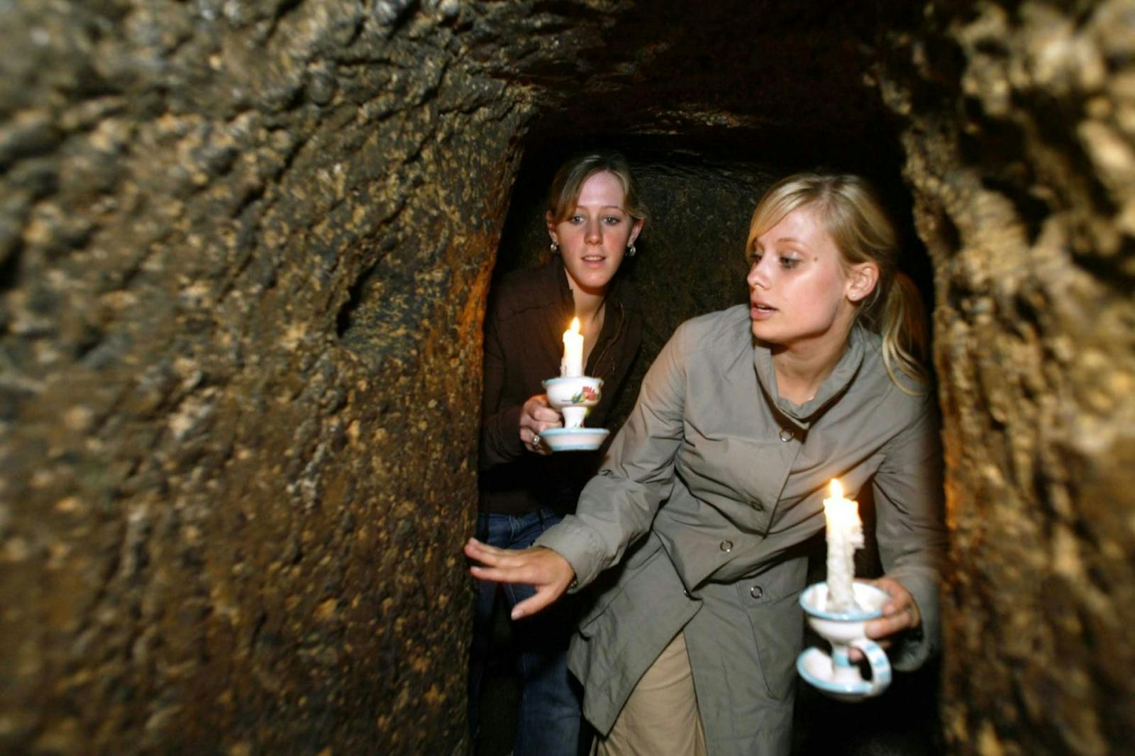 Zwiedzające kobiety oświetlają Podziemia Neapolu świecami